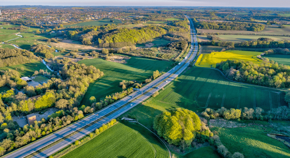 Luftbillede af Danmark med landbrug, motorvej og husstande